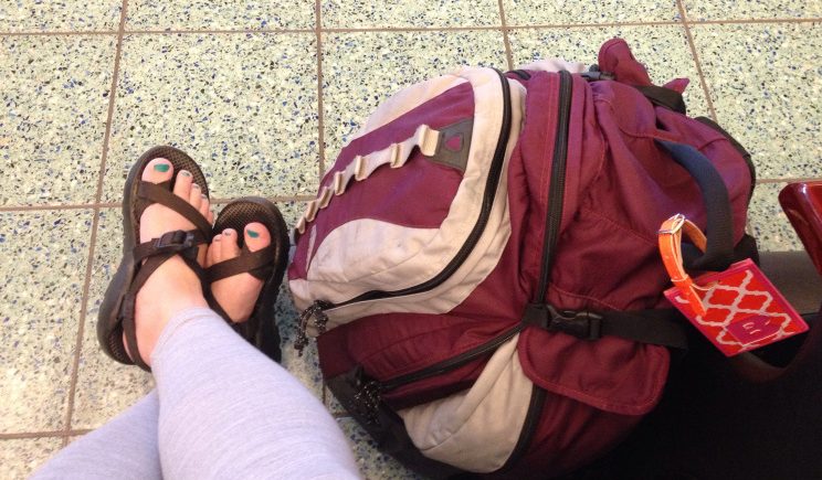 Red Kelty carry-on backpack, chaco sandals