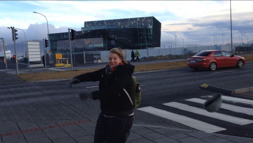 Hat blowing off in front of the Harpa, Iceland