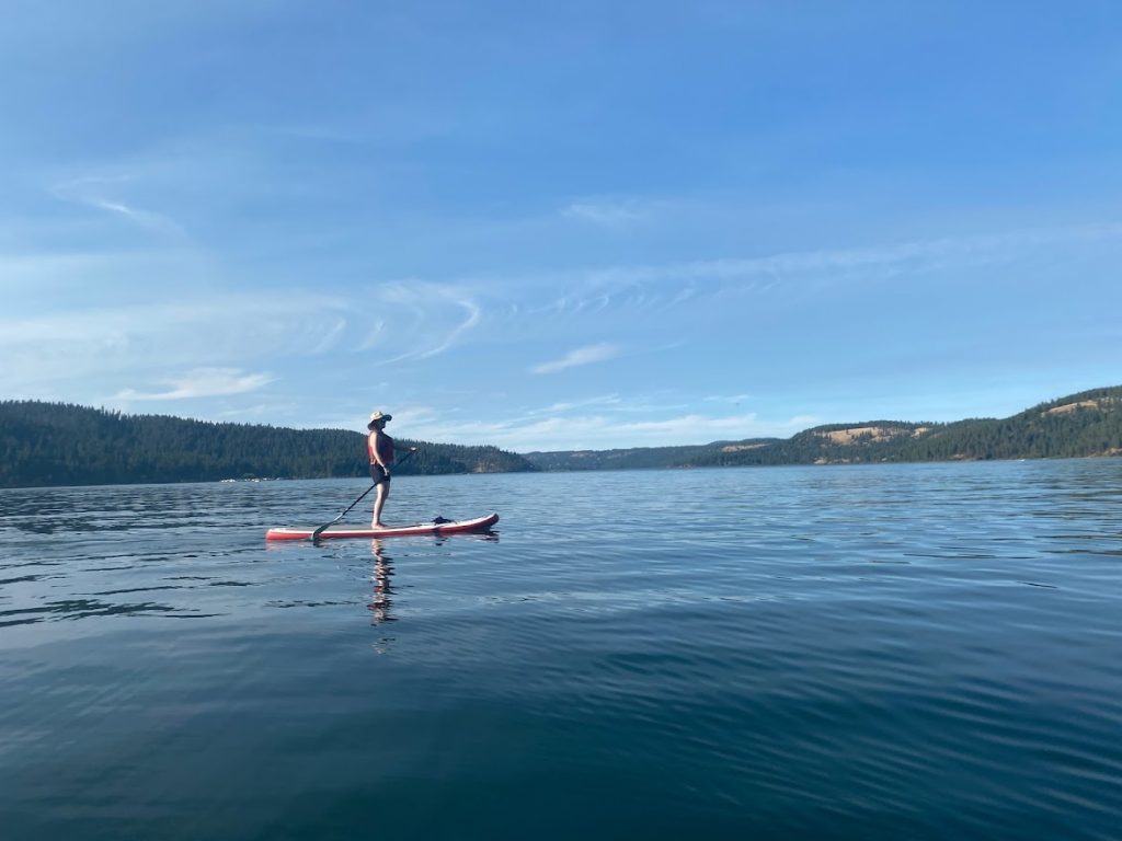 Blue skies, girls paddle boarding on Lake Coeur d'Alene