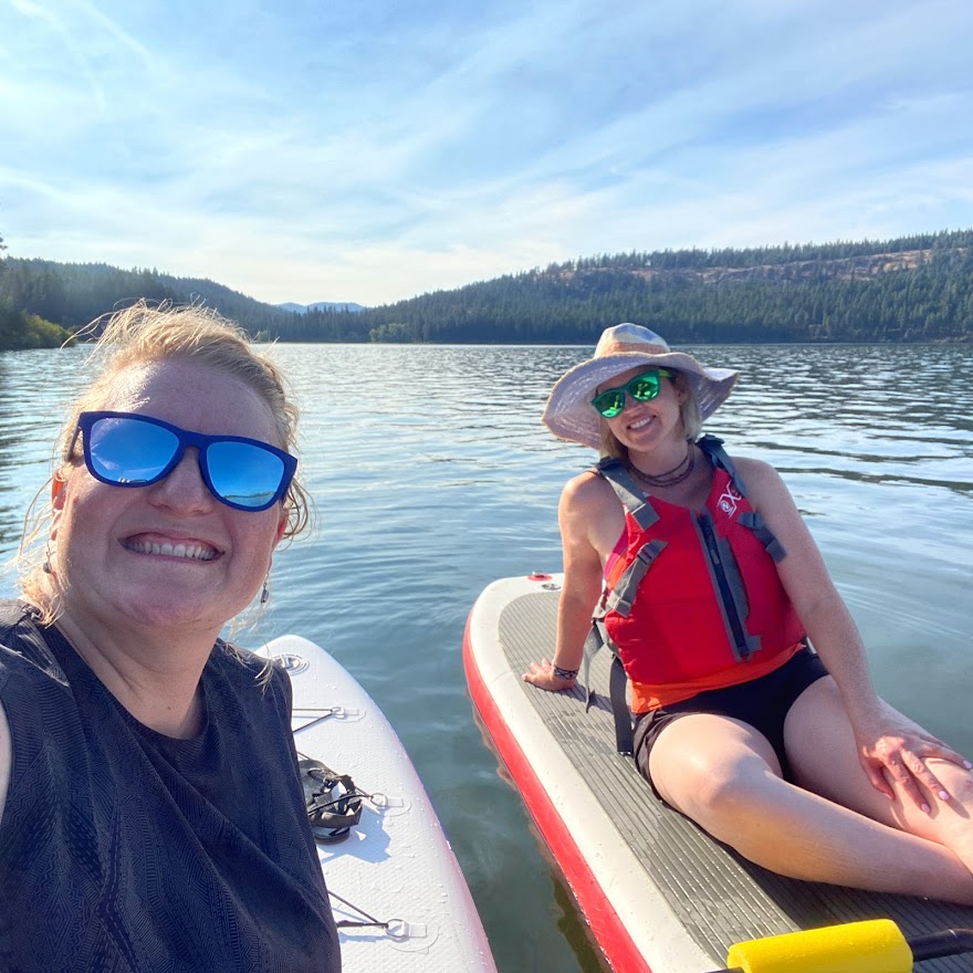 Two girls sitting on paddle boards in Northern Idaho