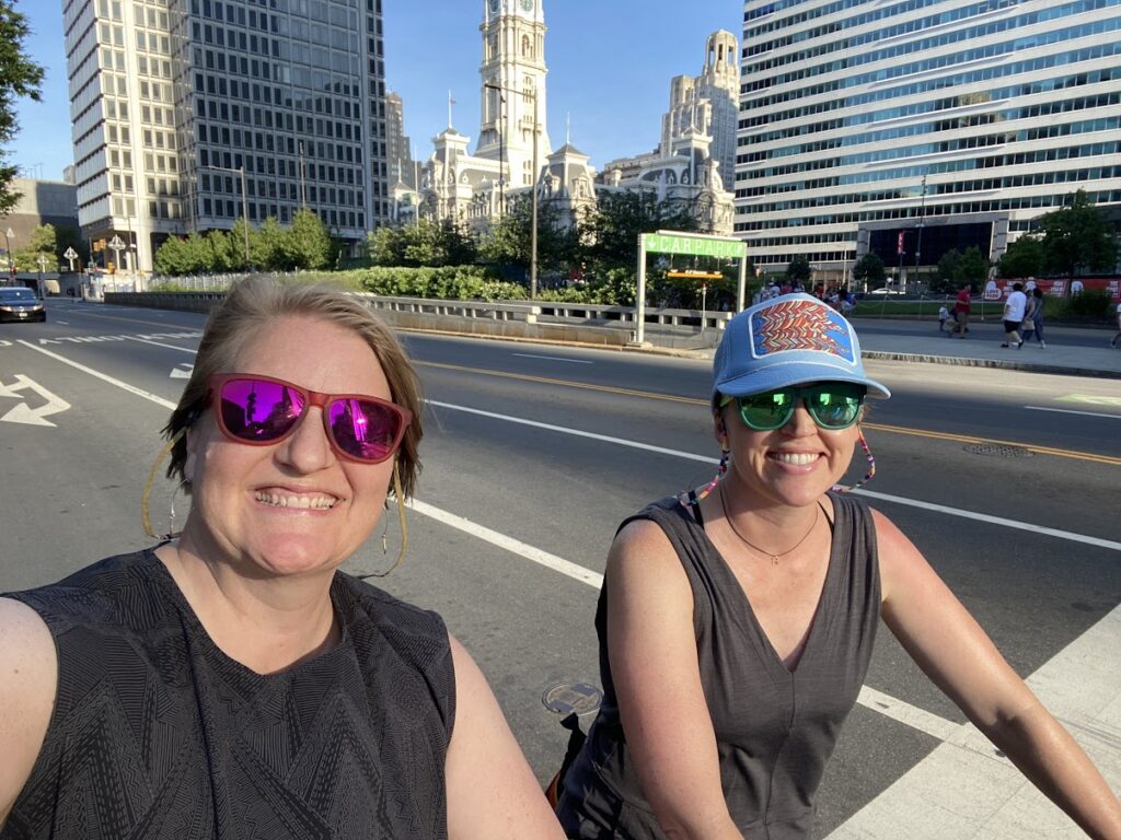 Two girls on bikes in downtown Philadelphia.