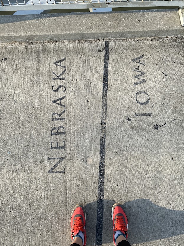Two feet, red shoes on the state line of Nebraska and Iowa. A fun thing to do if you work and travel in Omaha.
