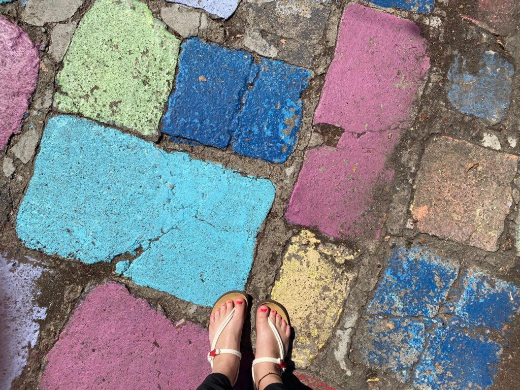 Curious Red sandals on a colorful painted street