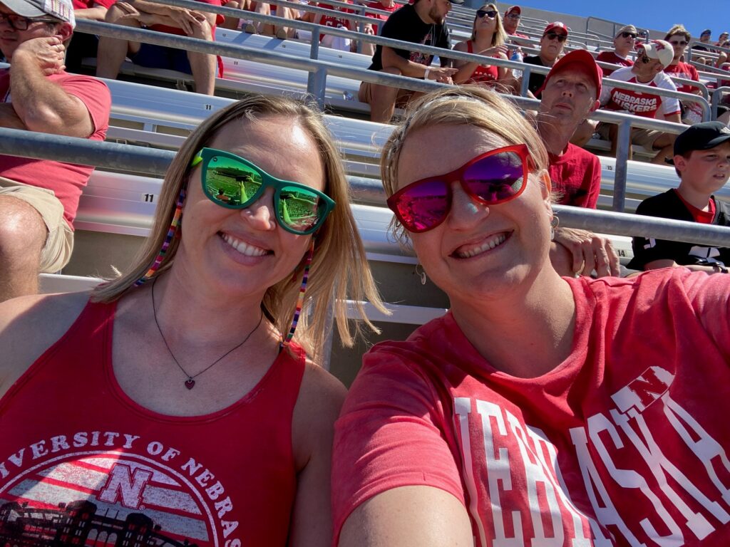Two friends at a Nebraska football game. This is how to plan your fun as a digital nomad.
