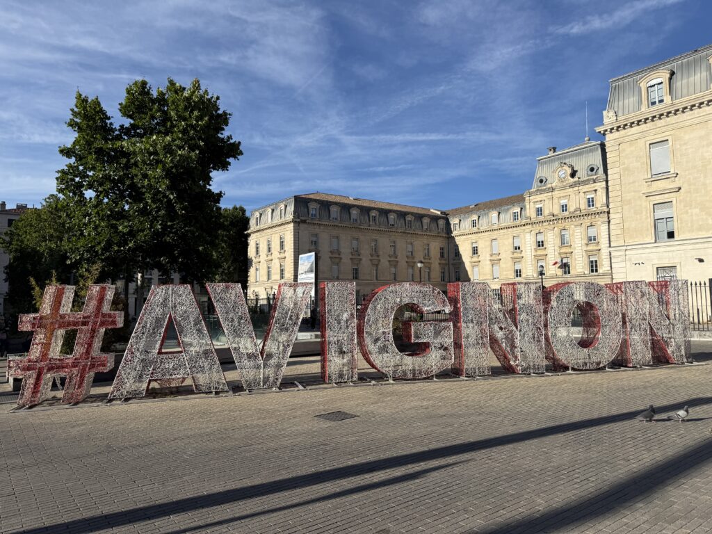 letters spelling Avignon in front of the city