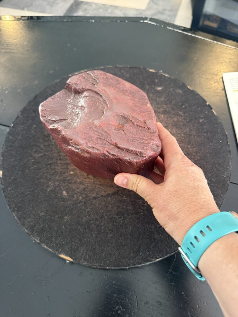 large red rock next to a hand the same size