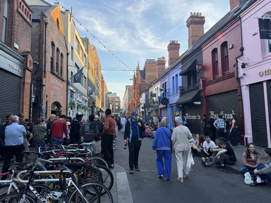 busy street with people sitting on the curb