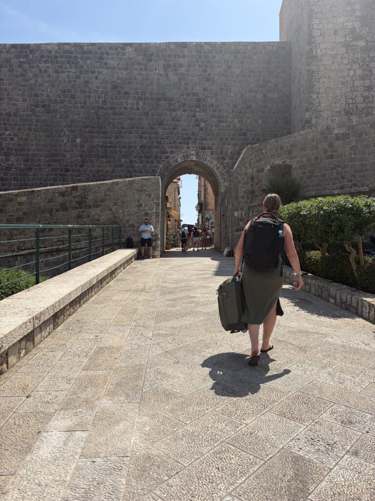 woman carrying bag on cobblestones