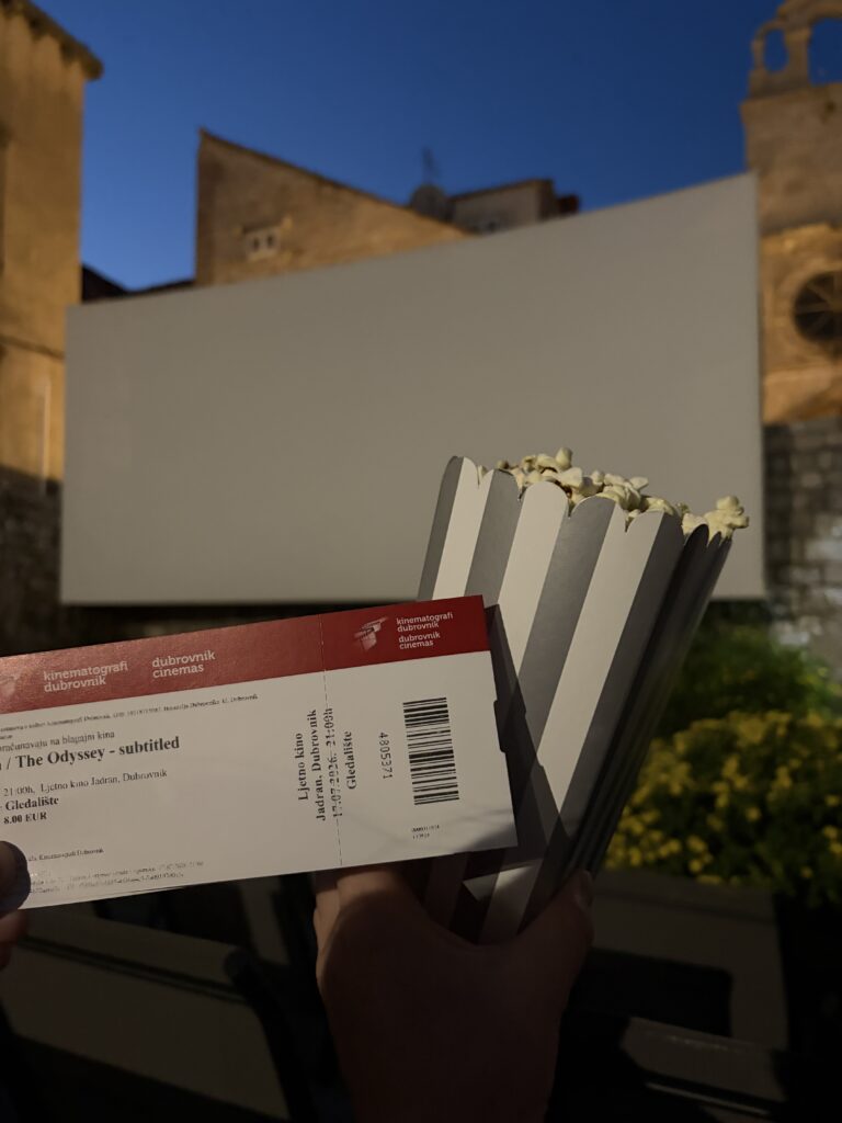 movie ticket and popcorn in front of outdoor screen