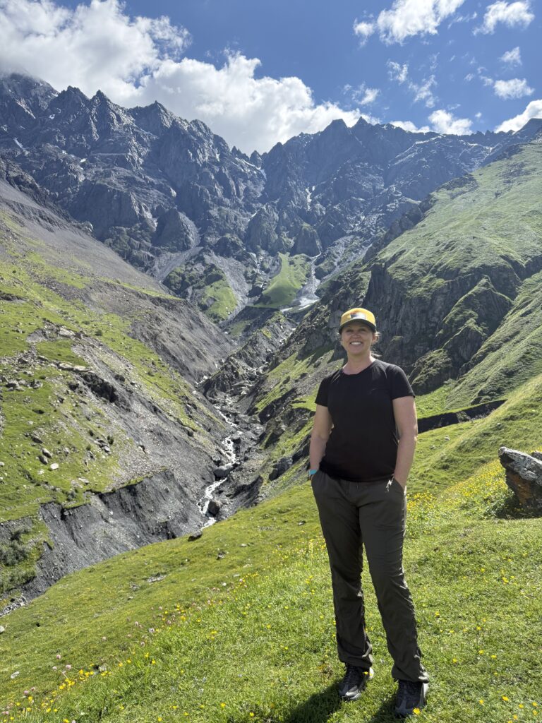 woman standing in front of green hillside
