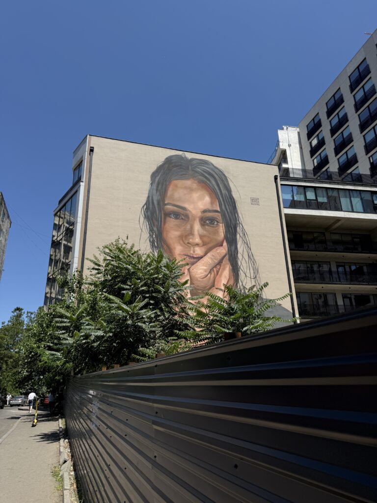 Painted portrait of woman on the side of a building.
